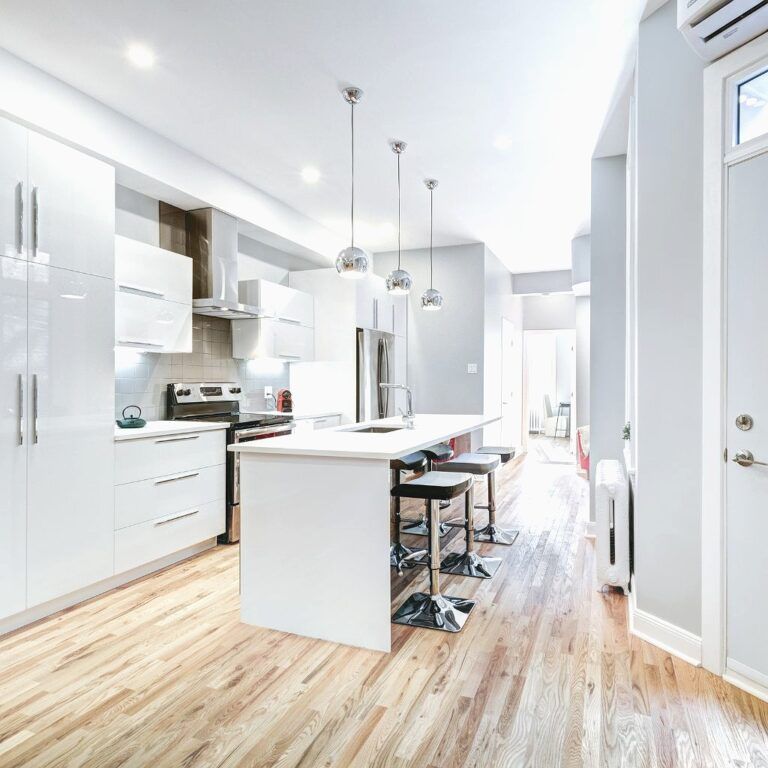 Reforma de cocina lacada en blanco con suelo laminado de madera clara y encimera de material compacto en Illescas.