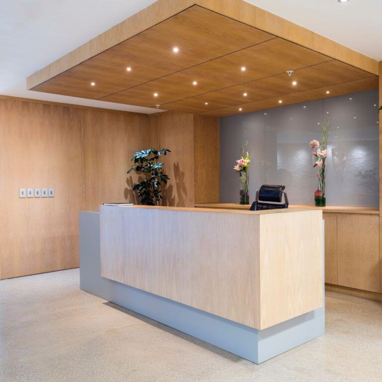 Recepción de oficina reformada en Illescas, con mostrador moderno, zona de espera y acabados funcionales para crear una imagen profesional.