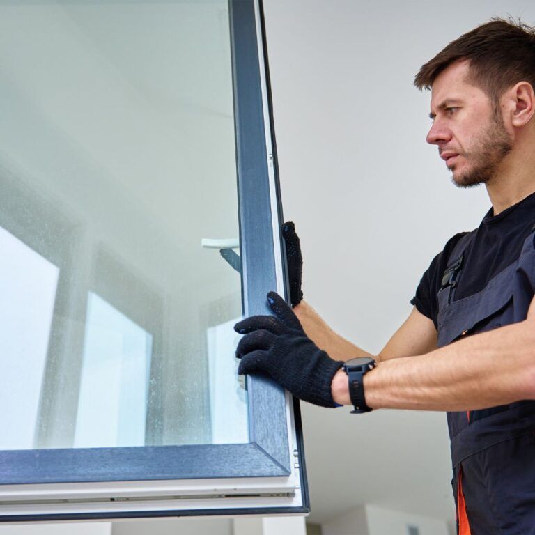 Operario sujetando una ventana de PVC durante su instalación en Illescas