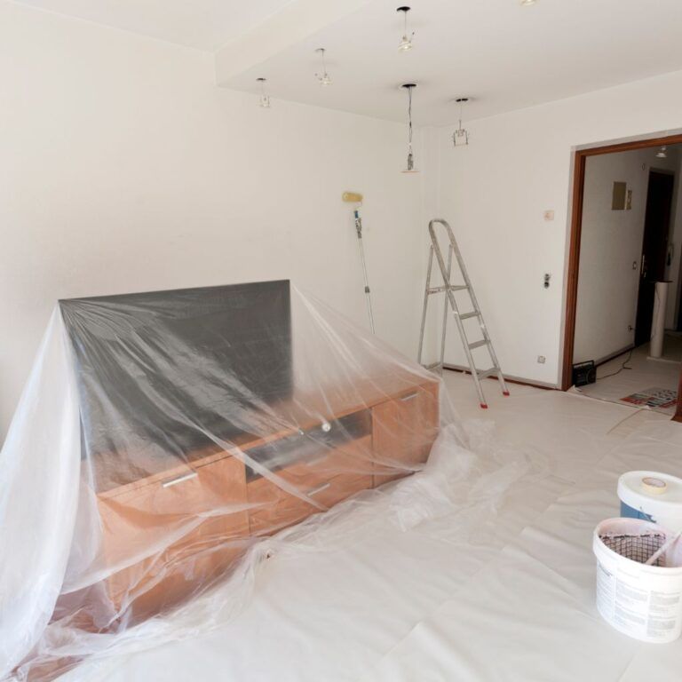 Muebles y suelos cubiertos con plásticos protectores antes de iniciar un trabajo de pintura en Illescas